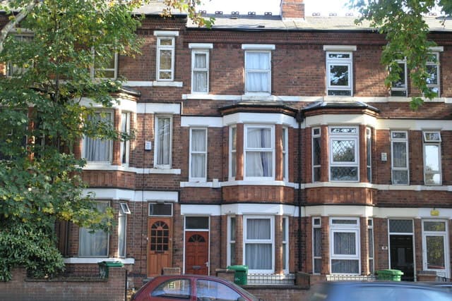 A Victorian red-brick terrace in Nottingham with bay windows and front doors opening onto the street.